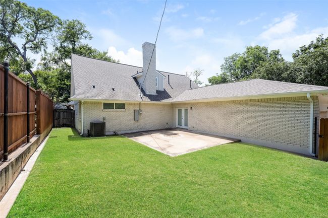 Back of house with roof with shingles, a fenced backyard, a patio area, brick siding, and a chimney | Image 24