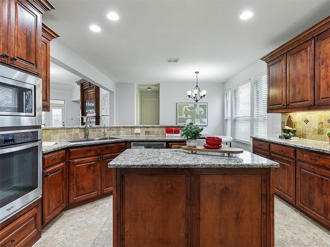 Kitchen with appliances with stainless steel finishes, backsplash, healthy amount of natural light, a center island, and recessed lighting | Image 11