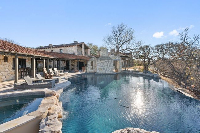 View of pool with a patio area and a pool with connected hot tub | Image 18