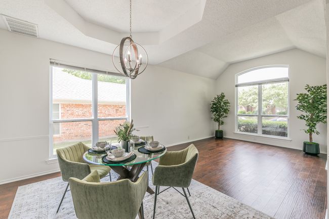 Dining space with visible vents, a wealth of natural light, a notable chandelier, and dark wood-style flooring | Image 12