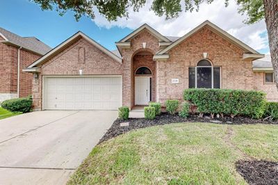 View of front of home featuring a front yard and a garage | Image 1