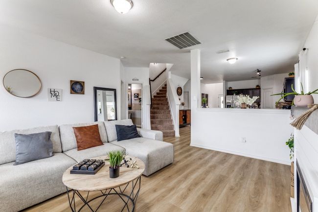 Living room with light wood-type flooring and stairs | Image 9