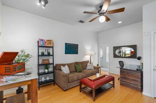 Living room featuring ceiling fan, light wood-style flooring, an office area, and recessed lighting | Image 7