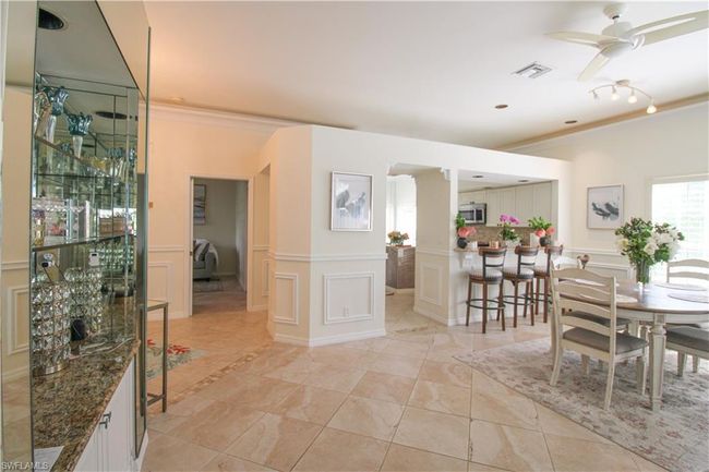 Dining room featuring ceiling fan, ornamental molding, and light tile floors | Image 17