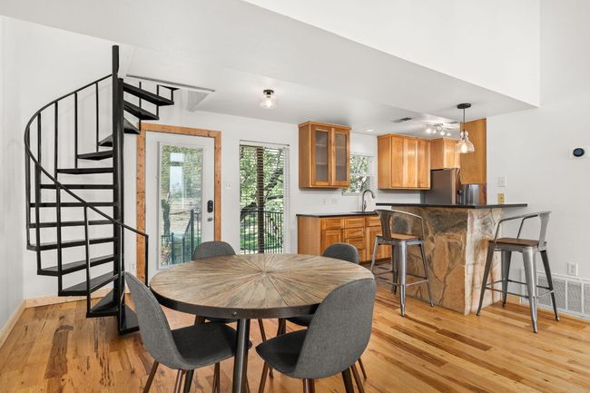 Dining are with hickory and pecan floors, and spiral staircase leading up to the loft | Image 12