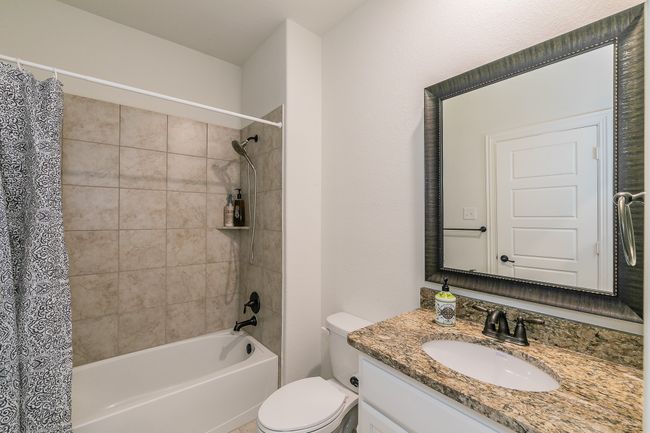 Bathroom with vanity, shower / bath combination with curtain, and toilet | Image 7