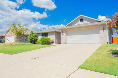 Ranch-style home featuring a front yard and a garage | Image 2