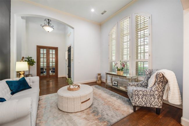 Living room featuring wood finished floors, crown molding, and arched walkways | Image 28