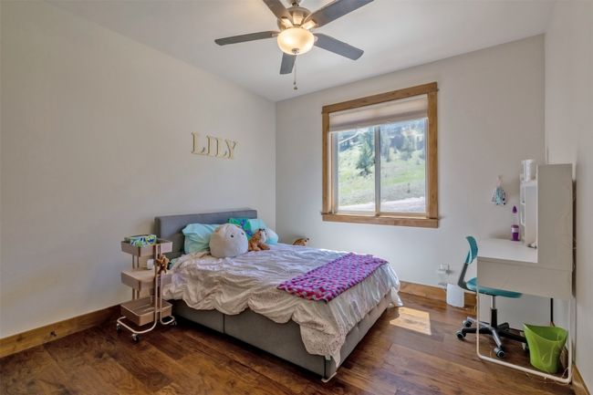 Bedroom with wood finished floors and ceiling fan | Image 26