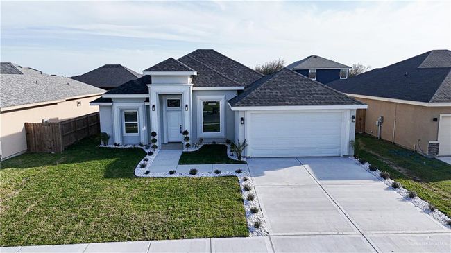 View of front of property featuring stucco siding, an attached garage, a front yard, fence, and driveway | Image 5