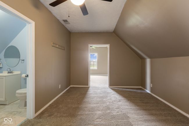 additional living space featuring baseboards, a ceiling fan, visible vents, lofted ceiling, and a sink | Image 20