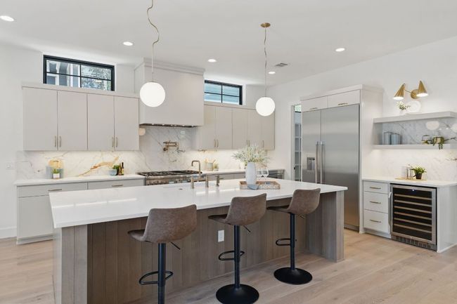 Kitchen with wine cooler, built in refrigerator, tasteful backsplash, light wood-style floors, and recessed lighting | Image 6