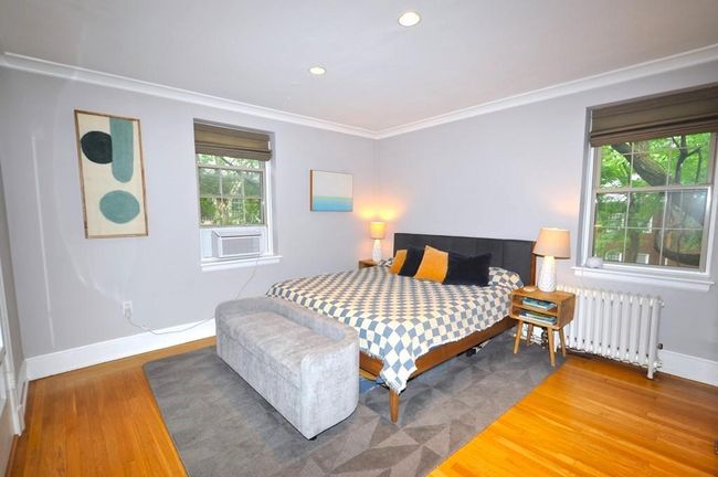 Corner main bedroom has hardwood floor and access to the renovated bathroom. The bedroom is 14'-7" x 13'-2". | Image 18