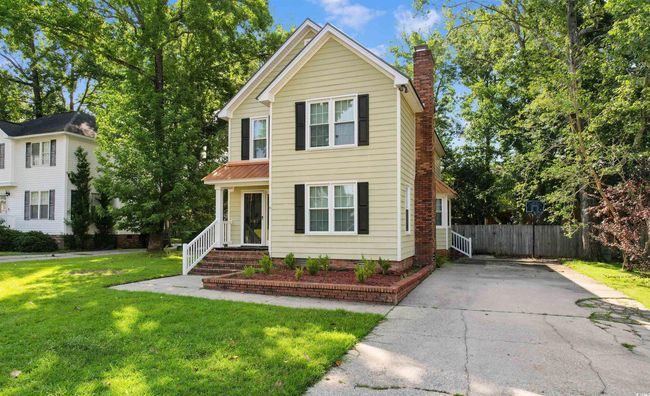 Traditional home featuring a chimney and driveway | Image 29