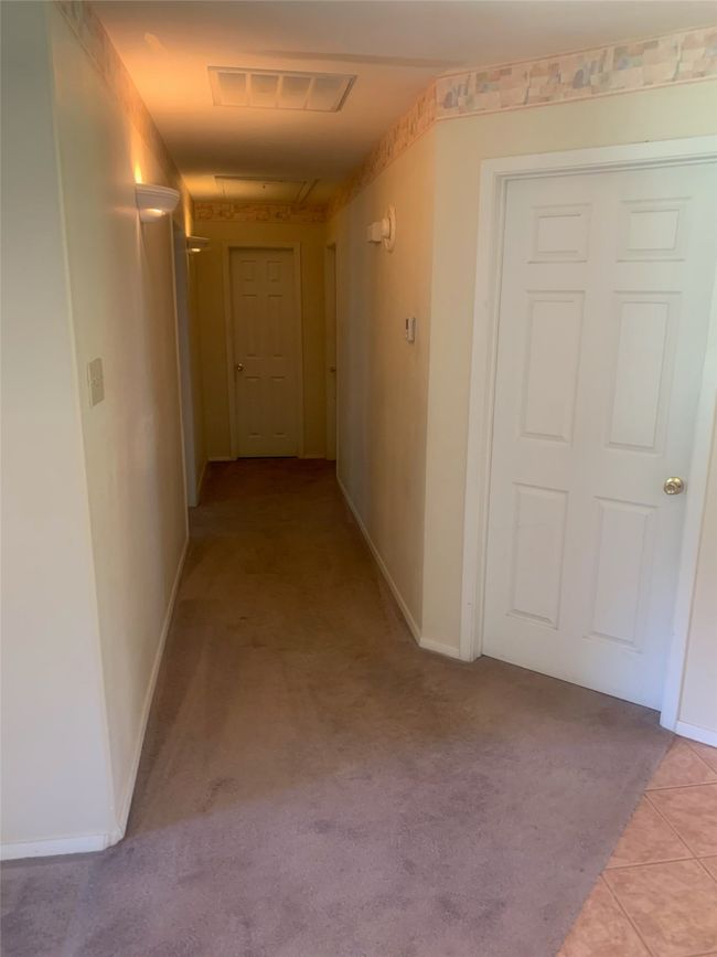 Hall featuring light carpet and baseboards | Image 8