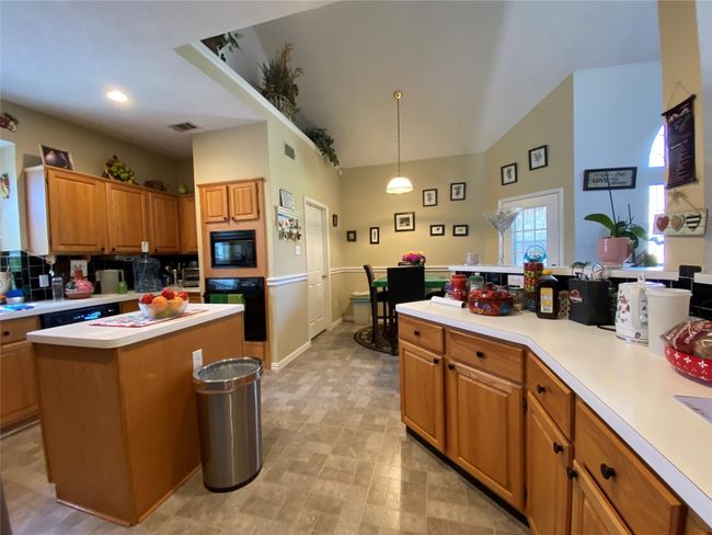 Kitchen with black appliances, a center island, and pendant lighting | Image 22