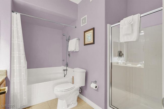Full bathroom featuring a shower with curtain, toilet, visible vents, tiled bath, and tile patterned flooring | Image 21