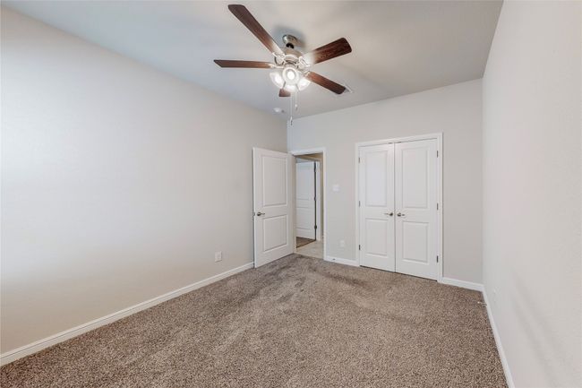 Unfurnished bedroom featuring carpet flooring, baseboards, a closet, and ceiling fan | Image 25