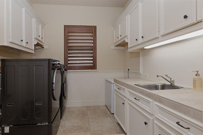 Laundry room with cabinetry and utility sink | Image 25