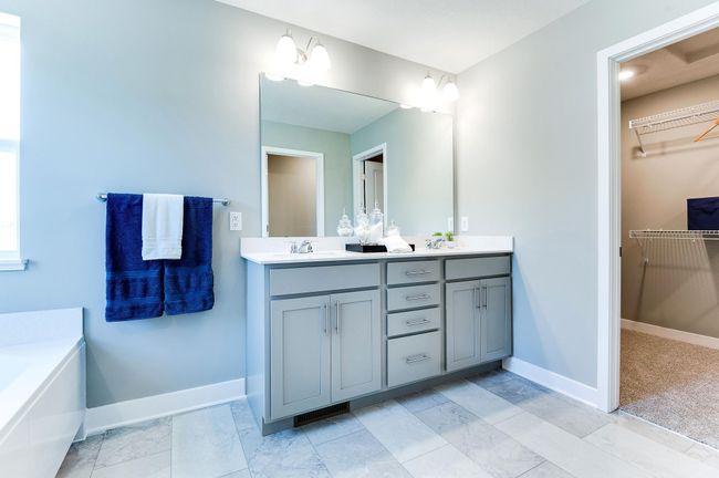 An extension of the primary suite, this private and spacious bathroom contains a double-vanity, an oversized stand-in shower, soaking tub, private stool room and access to a HUGE walk-in closet!! Photo of model home, color and options will vary. | Image 27