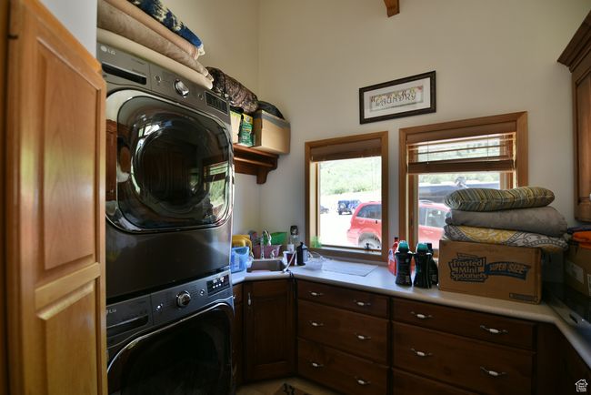 Clothes washing area with cabinet space and stacked washer and dryer | Image 75