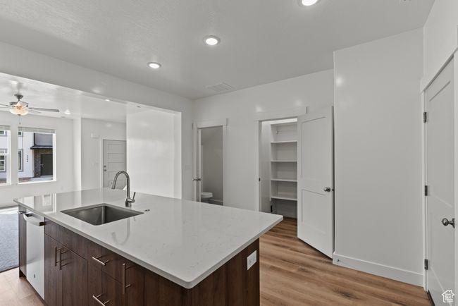 Kitchen featuring light wood finished floors, dishwasher, a sink, and ceiling fan | Image 4