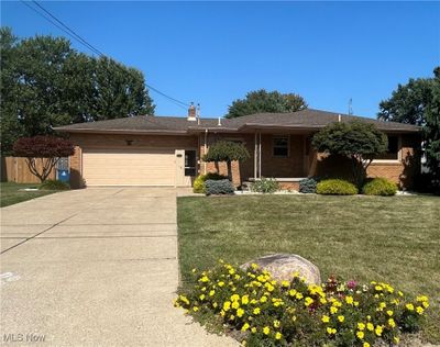 Single story home featuring a garage and a front lawn | Image 1