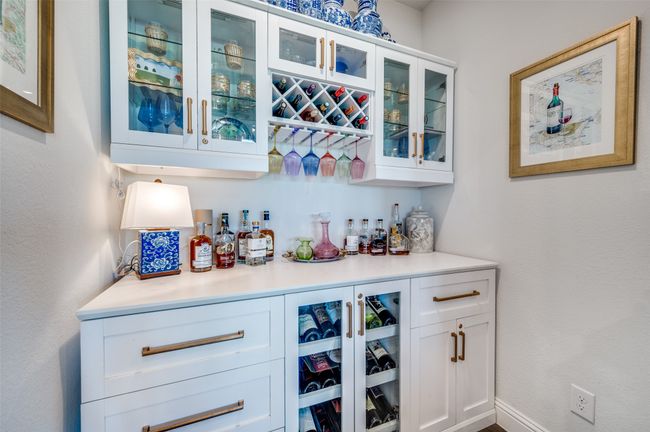 This nook boasts a dry bar with bottle display, glassed cabinets and wine storage. | Image 16