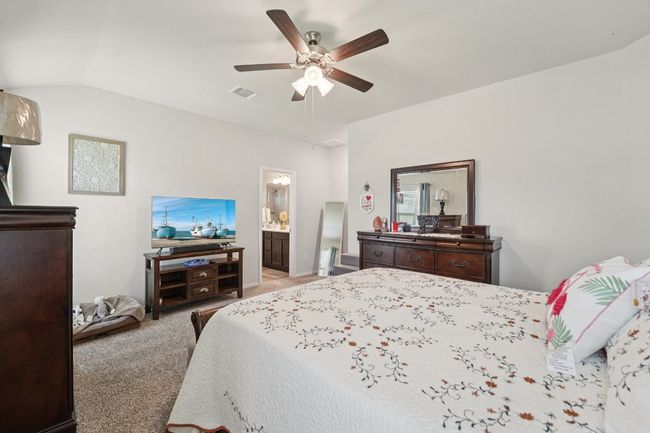 Bedroom with carpet flooring, a ceiling fan, lofted ceiling, and ensuite bath | Image 27