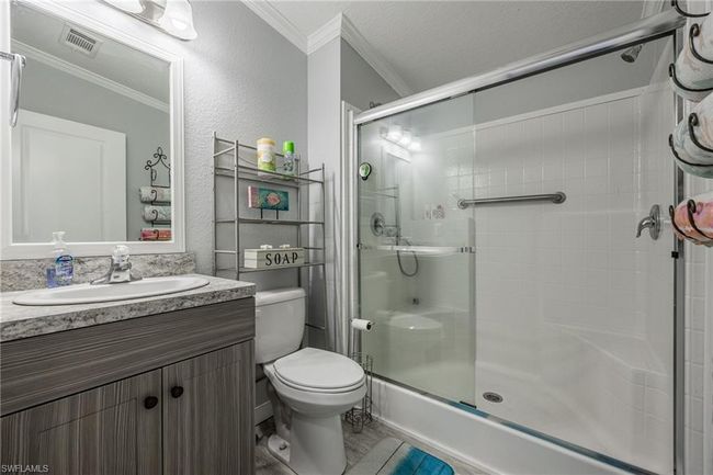 Full bathroom with ornamental molding, a stall shower, toilet, and visible vents | Image 21