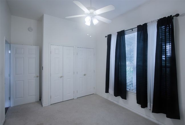 Unfurnished bedroom with carpet, multiple windows, and ceiling fan | Image 17