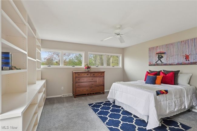Carpeted bedroom featuring baseboards, visible vents, and ceiling fan | Image 25