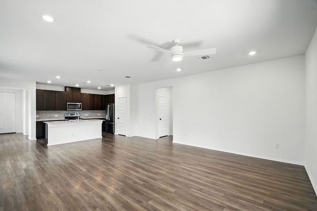 Unfurnished living room with recessed lighting, dark wood-type flooring, and a ceiling fan | Image 6