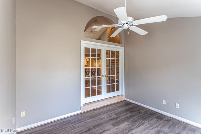 Empty room with dark wood-style floors, lofted ceiling, french doors, and ceiling fan | Image 22