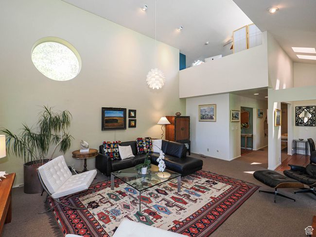 Carpeted living room featuring a high ceiling | Image 10