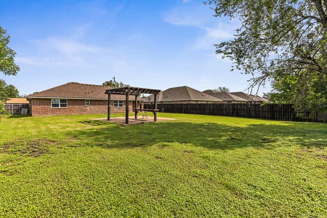 Fenced backyard with a pergola and a patio area | Image 12