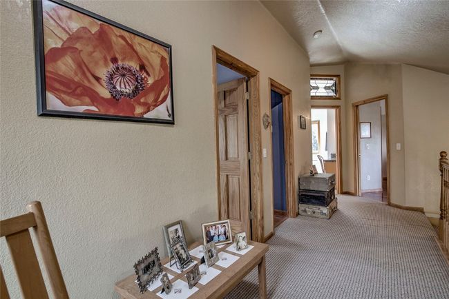 Hall with vaulted ceiling, carpet, a textured ceiling, and a textured wall | Image 38