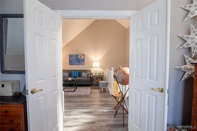 Sitting room with lofted ceiling and wood finished floors | Image 26