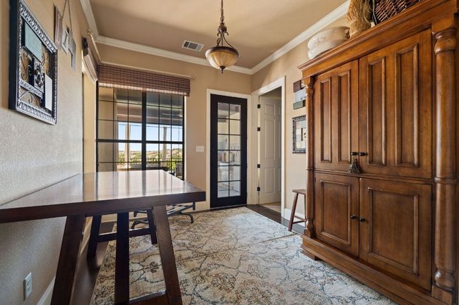 Entryway with a textured wall, wood finished floors, and ornamental molding | Image 21