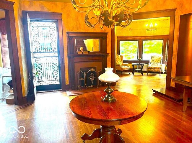 living area featuring wood finished floors, a wealth of natural light, and a chandelier | Image 4