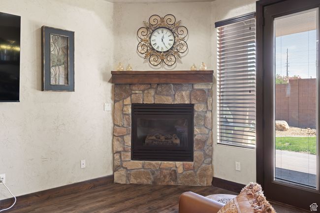 Living area featuring wood finished floors, a fireplace, and a textured wall | Image 39