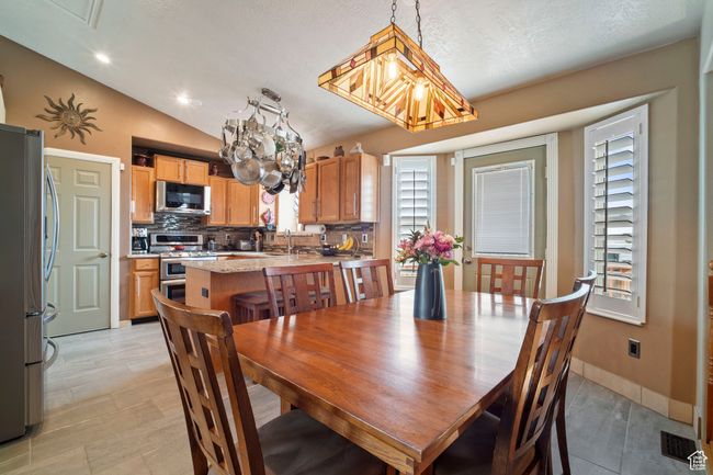 Dining room with baseboards, visible vents, an inviting chandelier, and vaulted ceiling | Image 6