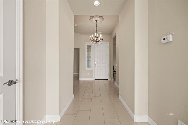 Hallway featuring baseboards, recessed lighting, a notable chandelier, and light tile patterned flooring | Image 10