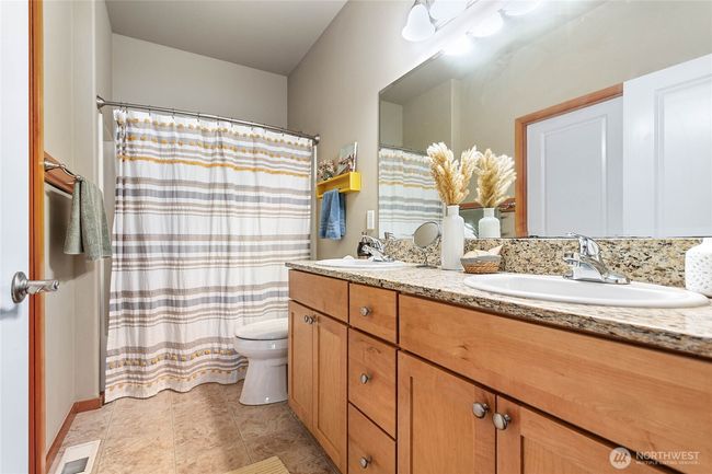 Main level primary suite with double sinks and granite counter | Image 15
