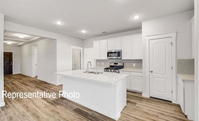 Kitchen featuring light hardwood / wood-style floors, white cabinetry, sink, and stainless steel appliances | Image 2