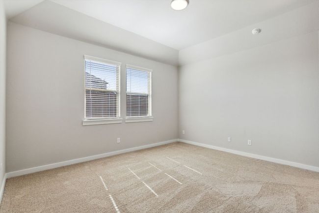 Unfurnished room with carpet flooring, baseboards, vaulted ceiling, and a smoke detector | Image 15