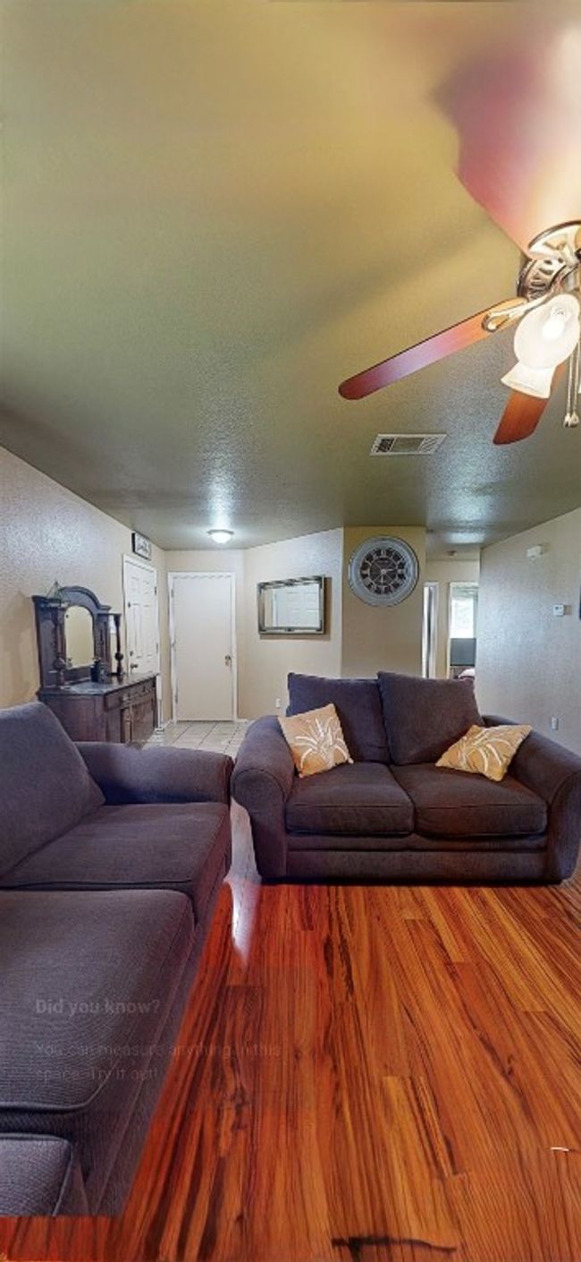Living room featuring ceiling fan, a textured ceiling, and wood finished floors | Image 11