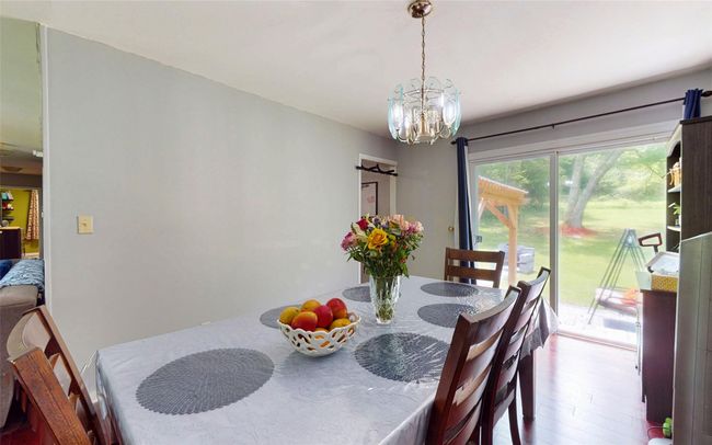 Dining space featuring a chandelier and wood finished floors | Image 18