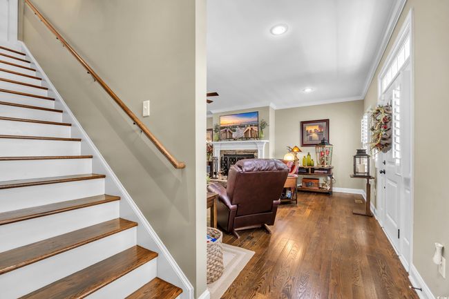 Staircase with a ceiling fan, recessed lighting, crown molding, a fireplace, and wood finished floors | Image 13
