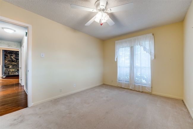 Carpeted spare room with a textured ceiling, baseboards, and a ceiling fan | Image 13